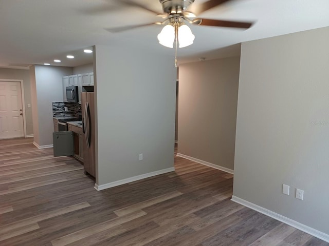 spare room featuring dark hardwood / wood-style flooring and ceiling fan