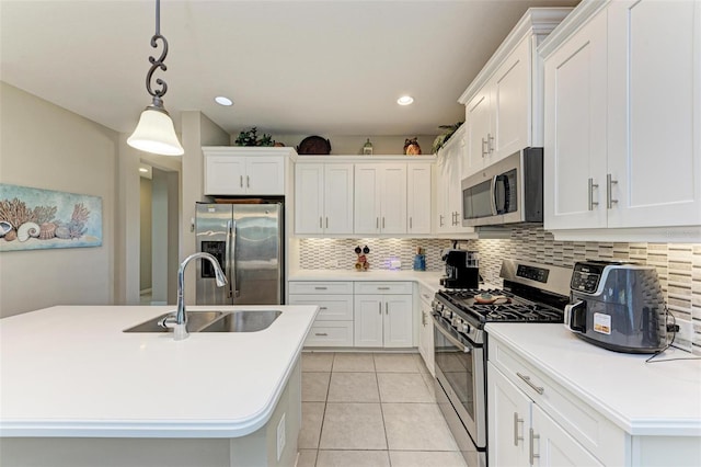 kitchen featuring sink, stainless steel appliances, backsplash, a kitchen island with sink, and white cabinets