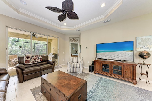 tiled living room with a tray ceiling and ornamental molding