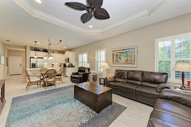 tiled living room featuring a raised ceiling, crown molding, and ceiling fan