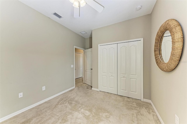 unfurnished bedroom with ceiling fan, a closet, and light carpet