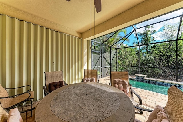 sunroom with ceiling fan and a swimming pool