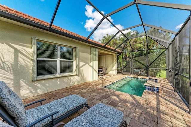 view of pool with glass enclosure and a patio area