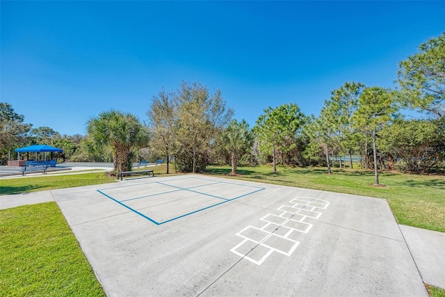 view of community with a lawn and basketball hoop