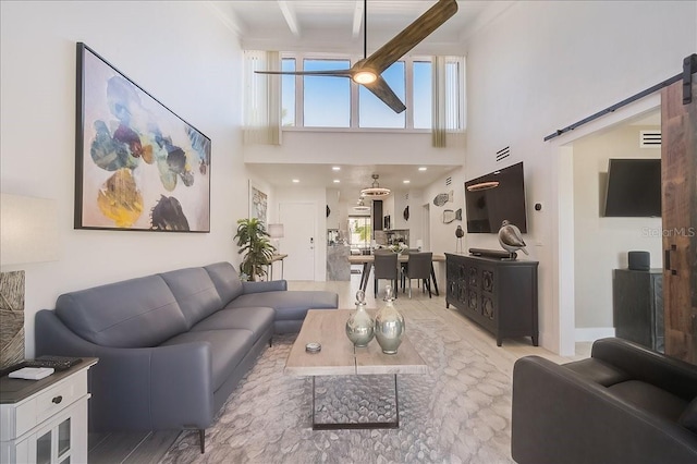 living room featuring beamed ceiling, a towering ceiling, and a barn door