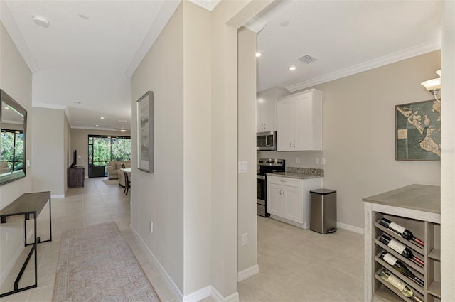 hallway with light tile patterned floors and crown molding