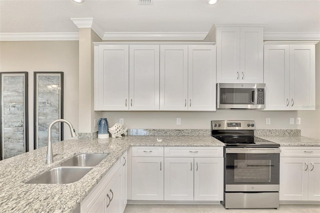 kitchen featuring stainless steel appliances, white cabinetry, ornamental molding, and sink