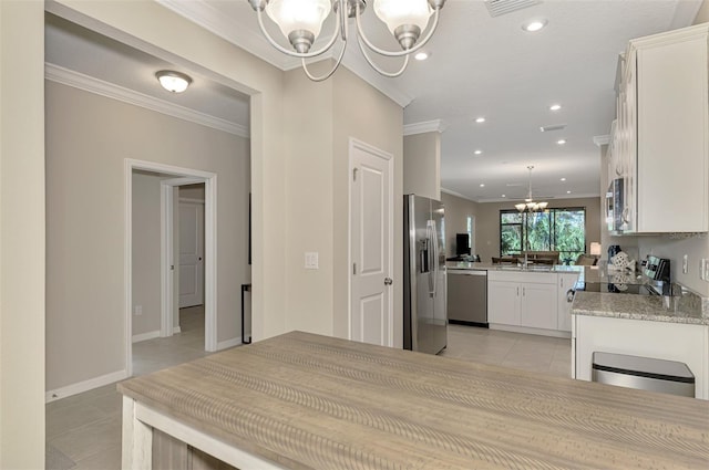 tiled dining area with ornamental molding, sink, and a chandelier