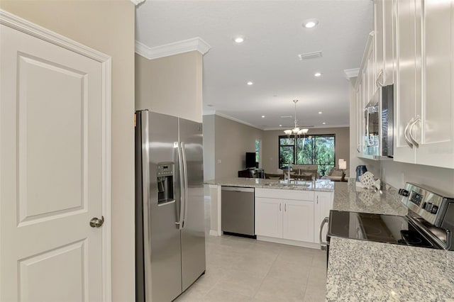 kitchen with white cabinetry, light stone countertops, an inviting chandelier, crown molding, and appliances with stainless steel finishes