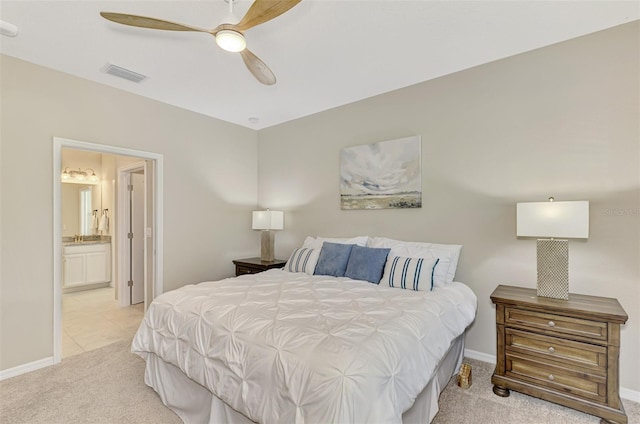 bedroom featuring ensuite bath, ceiling fan, and light colored carpet