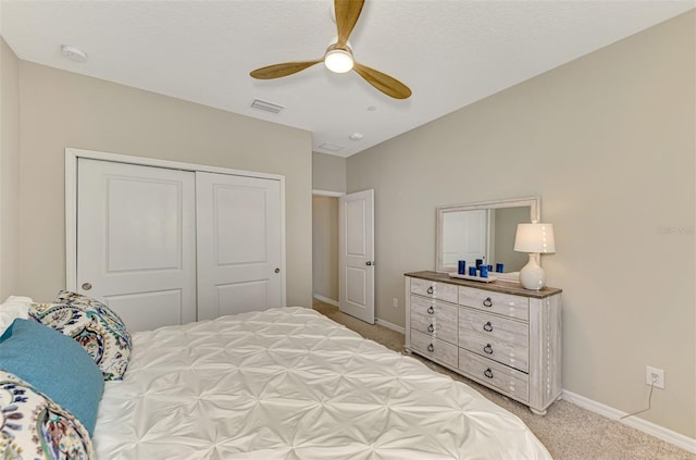 carpeted bedroom with ceiling fan and a closet