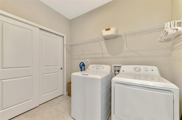 clothes washing area featuring light tile patterned floors and separate washer and dryer