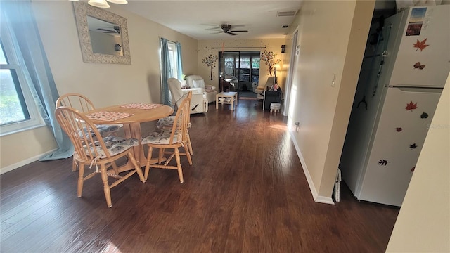 dining area with ceiling fan and dark wood-type flooring