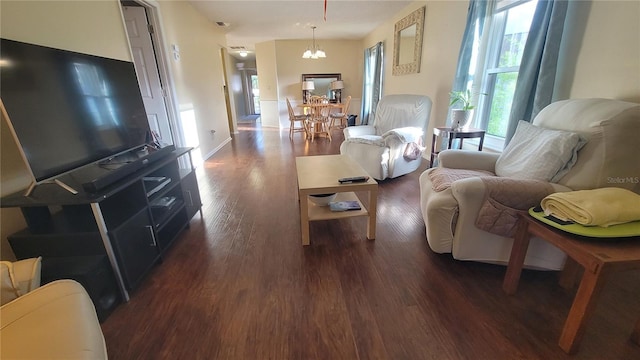 living room featuring dark hardwood / wood-style flooring and an inviting chandelier