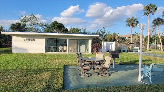 back of property with a sunroom and a lawn