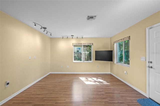 spare room with hardwood / wood-style flooring and track lighting