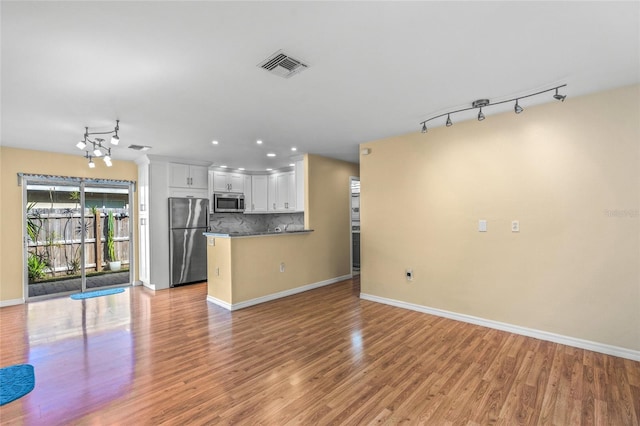 unfurnished living room with light wood-type flooring and a chandelier