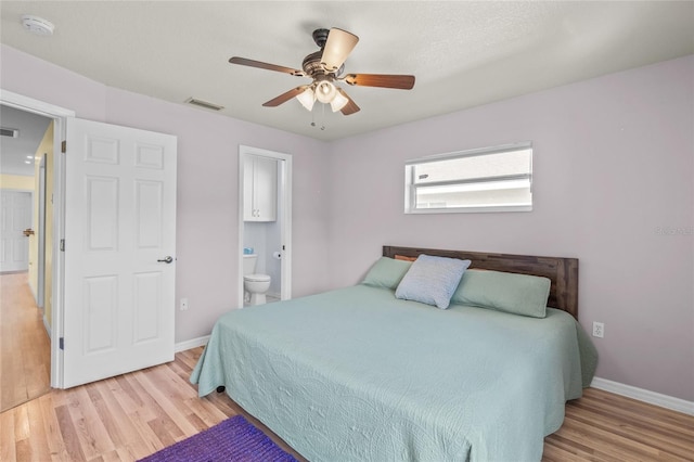 bedroom featuring ceiling fan, ensuite bathroom, and light hardwood / wood-style flooring