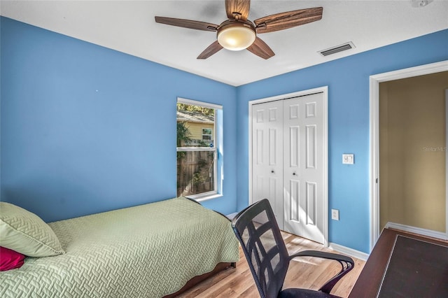 bedroom featuring ceiling fan, light hardwood / wood-style floors, and a closet