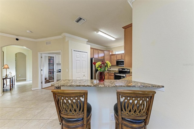 kitchen featuring a breakfast bar area, kitchen peninsula, and stainless steel appliances