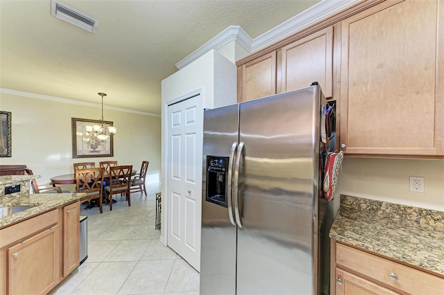 kitchen with stainless steel refrigerator with ice dispenser, ornamental molding, stone counters, a chandelier, and light tile patterned flooring