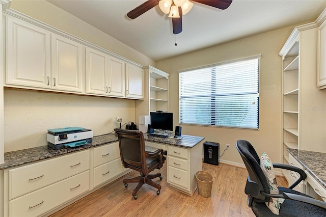 office space with ceiling fan, built in desk, and light hardwood / wood-style floors