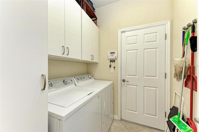 laundry room with cabinets, light tile patterned floors, and separate washer and dryer