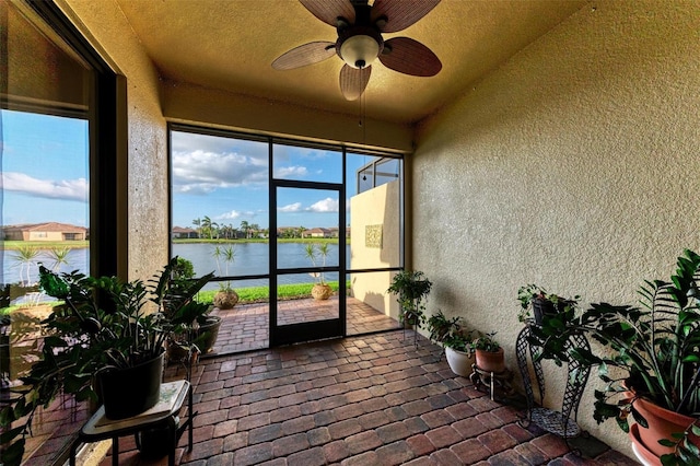 sunroom with a water view, plenty of natural light, and ceiling fan