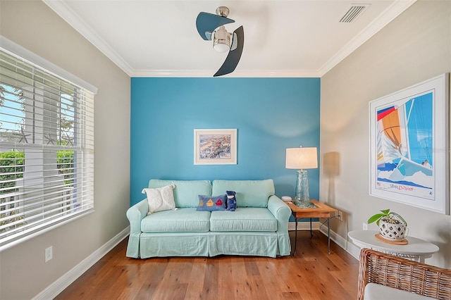 sitting room with ornamental molding, hardwood / wood-style flooring, and a healthy amount of sunlight