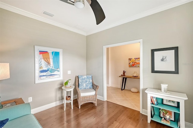 living area featuring crown molding, hardwood / wood-style floors, and ceiling fan