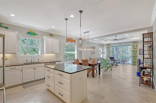 kitchen with light tile patterned floors, a kitchen island, a healthy amount of sunlight, and decorative light fixtures