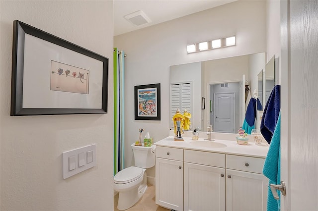 bathroom featuring tile patterned flooring, vanity, and toilet