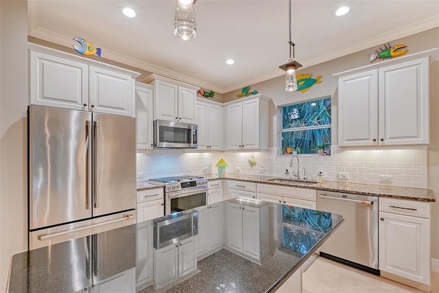 kitchen with white cabinetry, sink, stainless steel appliances, dark stone countertops, and crown molding