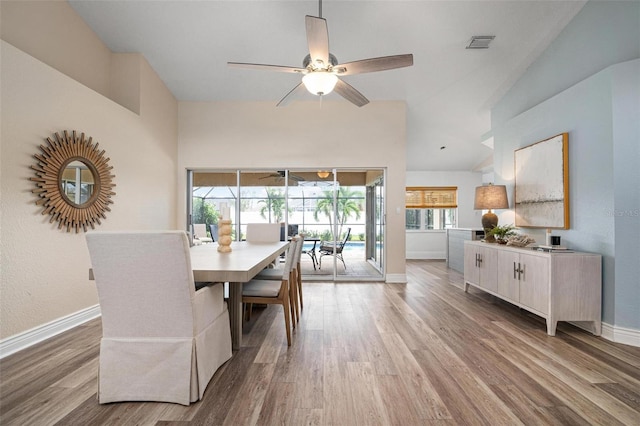 dining area with light hardwood / wood-style flooring, ceiling fan, and lofted ceiling