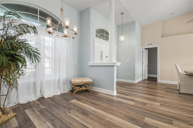 dining space with high vaulted ceiling, dark hardwood / wood-style floors, and an inviting chandelier