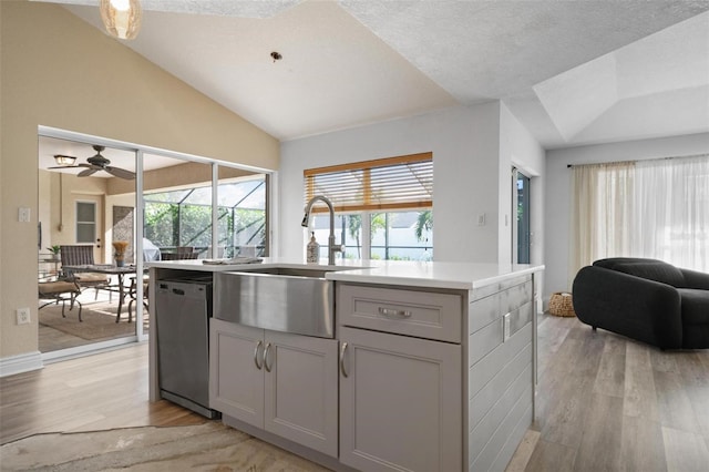 kitchen with dishwasher, lofted ceiling, sink, gray cabinets, and light wood-type flooring