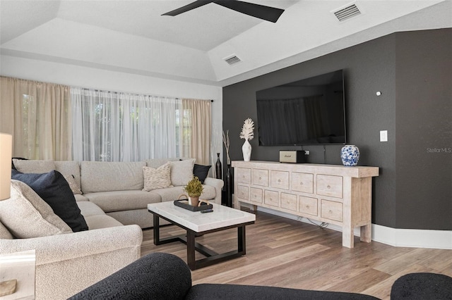 living room featuring ceiling fan, a raised ceiling, wood-type flooring, and vaulted ceiling