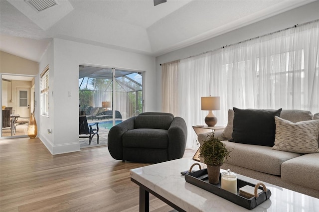 living room featuring light wood-type flooring and lofted ceiling