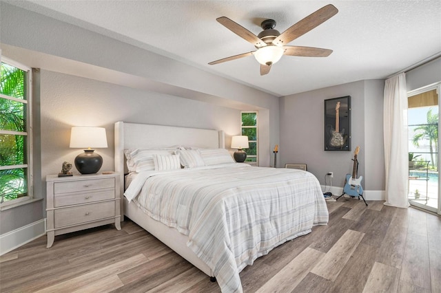 bedroom with access to outside, ceiling fan, light hardwood / wood-style floors, and a textured ceiling