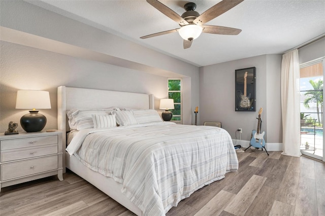 bedroom featuring access to outside, ceiling fan, a textured ceiling, and light wood-type flooring