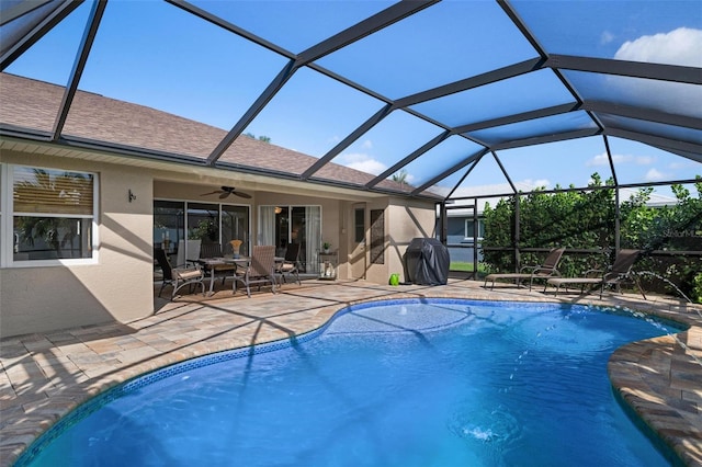 view of swimming pool featuring a patio, glass enclosure, ceiling fan, and a grill