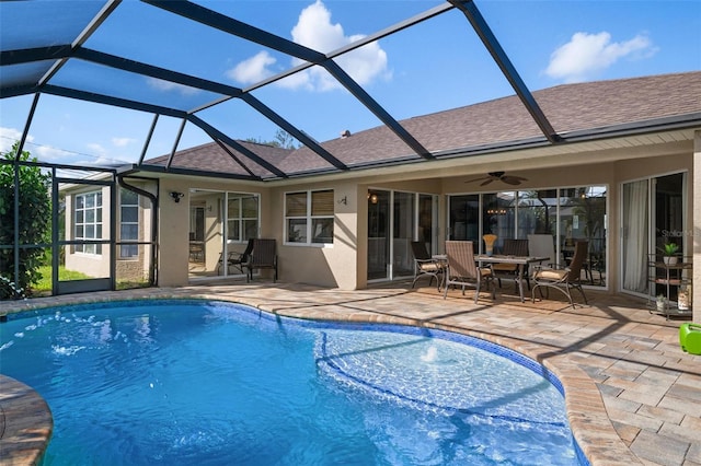 view of swimming pool with glass enclosure, ceiling fan, and a patio