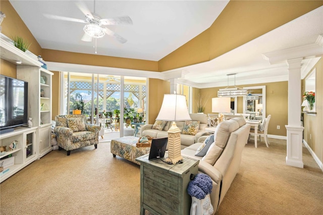 living room with decorative columns, ceiling fan, and light colored carpet