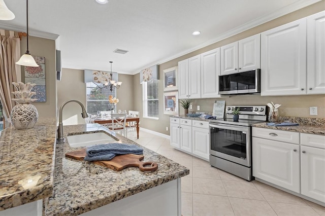 kitchen with white cabinets, appliances with stainless steel finishes, a chandelier, and sink