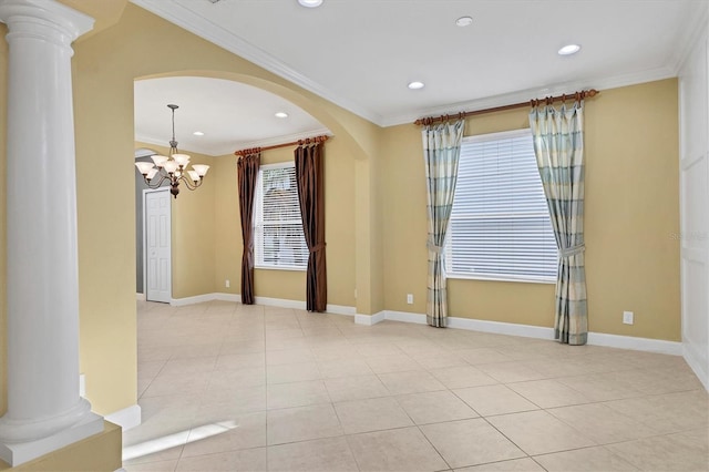 spare room featuring a notable chandelier, light tile patterned flooring, crown molding, and decorative columns