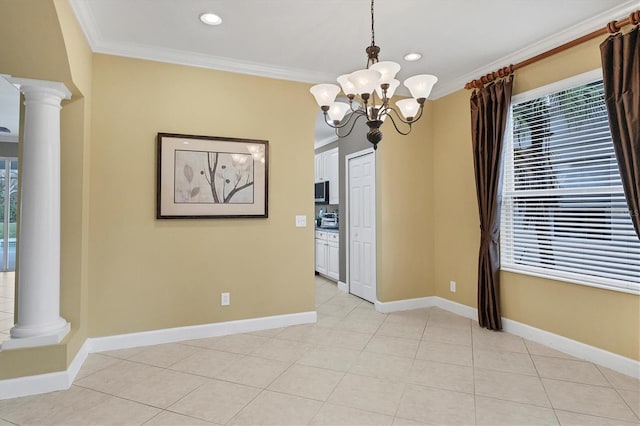 tiled spare room featuring an inviting chandelier, ornamental molding, and ornate columns