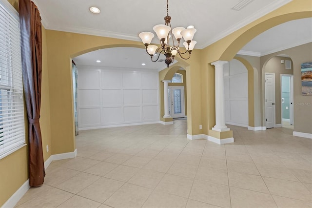 interior space with decorative columns, light tile patterned flooring, a notable chandelier, and ornamental molding