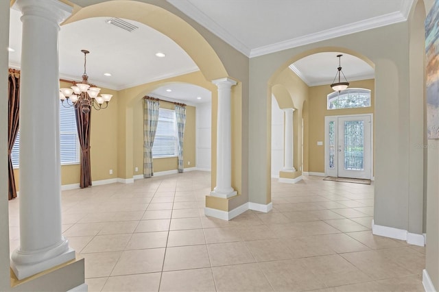 tiled foyer entrance featuring decorative columns, an inviting chandelier, and crown molding