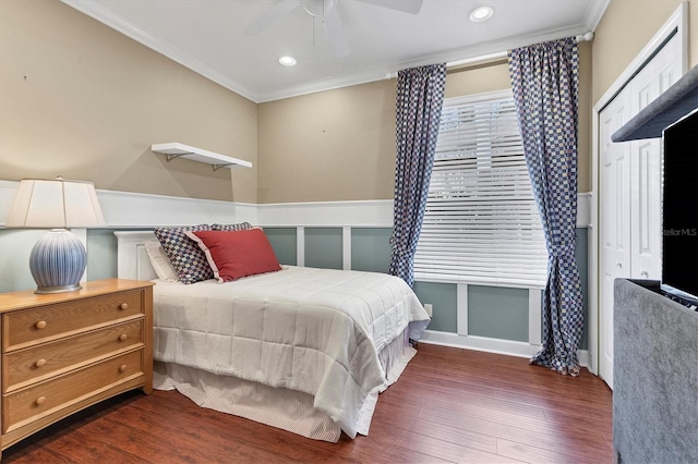 bedroom featuring dark hardwood / wood-style floors, ceiling fan, ornamental molding, and a closet