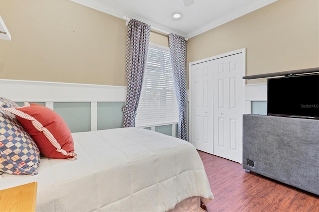 bedroom with crown molding, a closet, and dark wood-type flooring